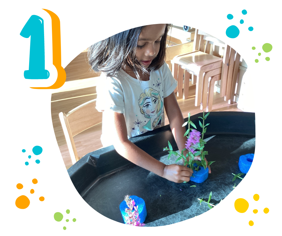 girl sticking flowers into a piece of foam