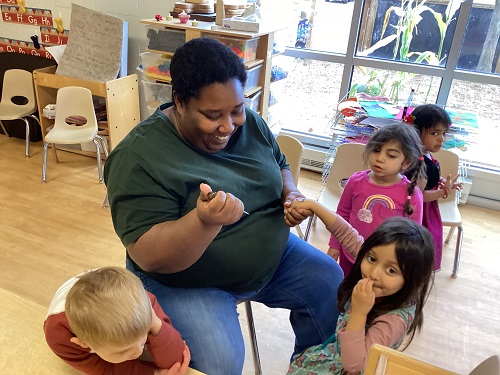 educator sitting with children doing some henna tattoos