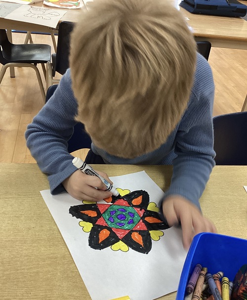 child colouring a Rangoli