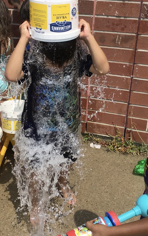 child dumping a bucket of water on their head