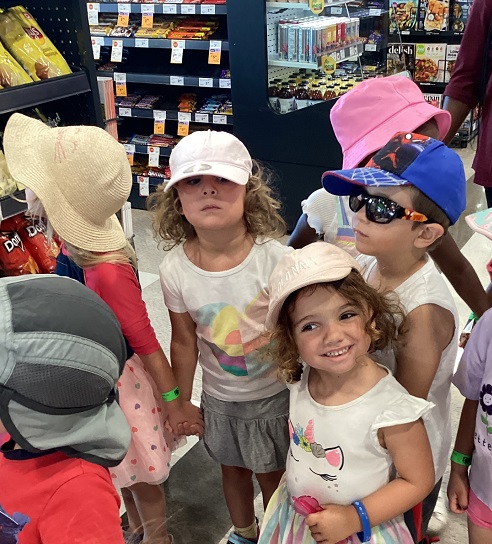 group of six children standing inside of the grocery store