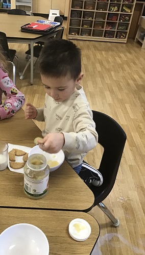 A child sccoping applesauce into a bowl