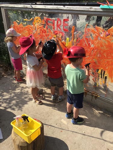 Children spraying paint off the mirror with water