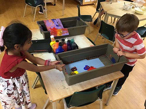 2 JKK children starting to make their marble painting masterpiece together