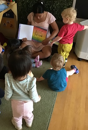 Toddler educator reading Pride book