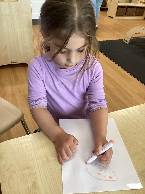 A child drawing a person.