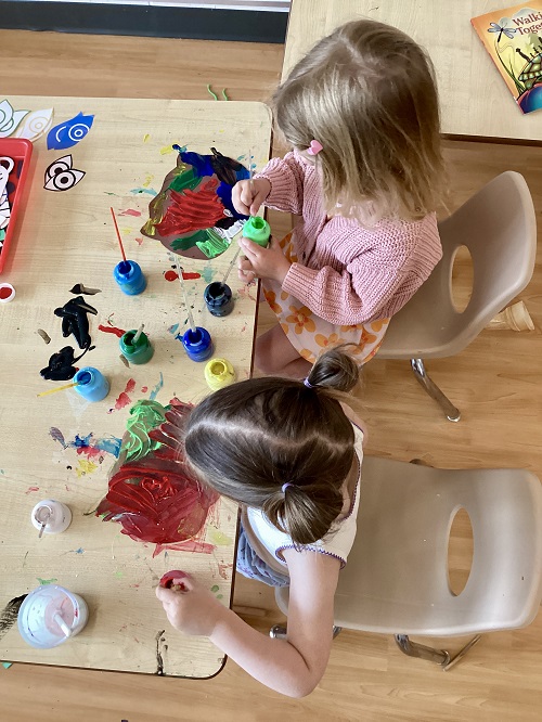 Two children working on their artistic creations.