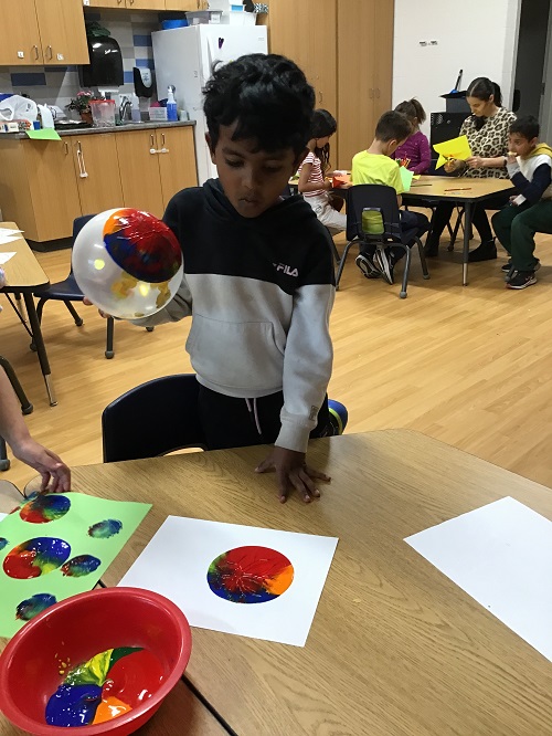 A child making a craft with their balloon.