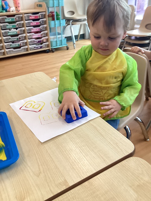 A child painting with letters.