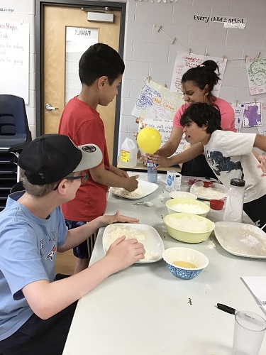 A group of school age children exploring different ingredients