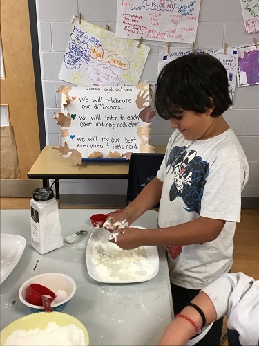 School aged child mixing ingredients together
