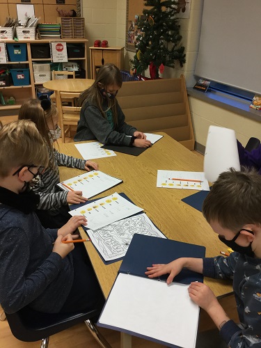 Children at a table writing