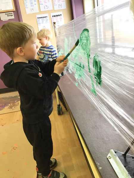 boy painting on a plastic canvas
