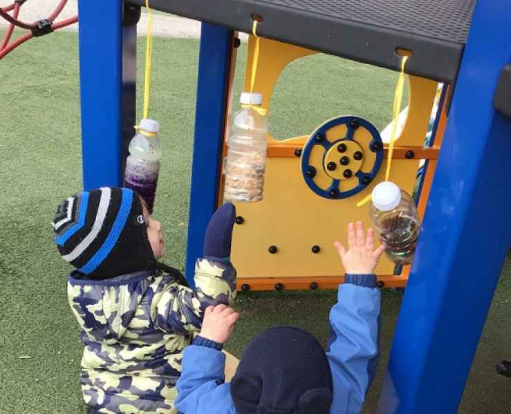 boys playing with hanging sensory bottles