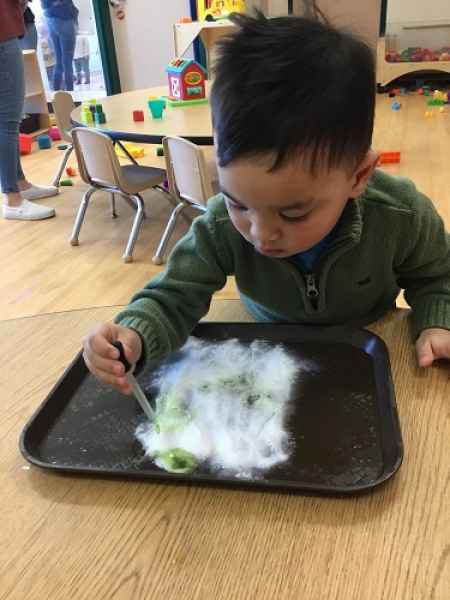 boy with dropper experimenting with sugar and colour water drops