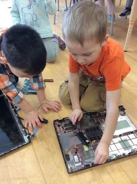 boys looking at the inside of an old computer
