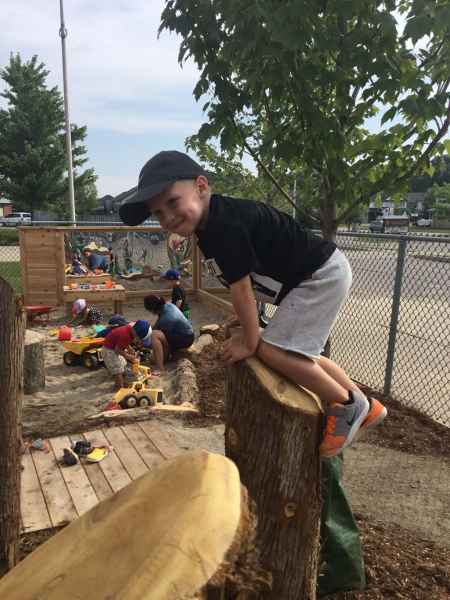 boy kneeling on a log