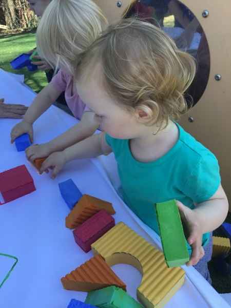 toddlers playing with blocks outside