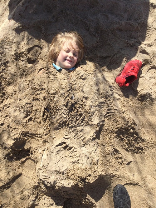 child burried in sand