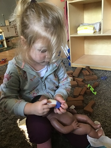 Lily doctoring her baby 