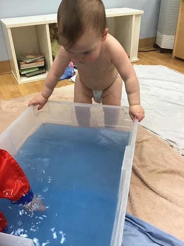 Child looking into water bin