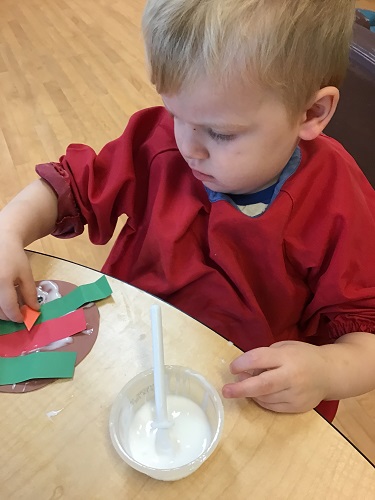 Beau gluing paper feathers
