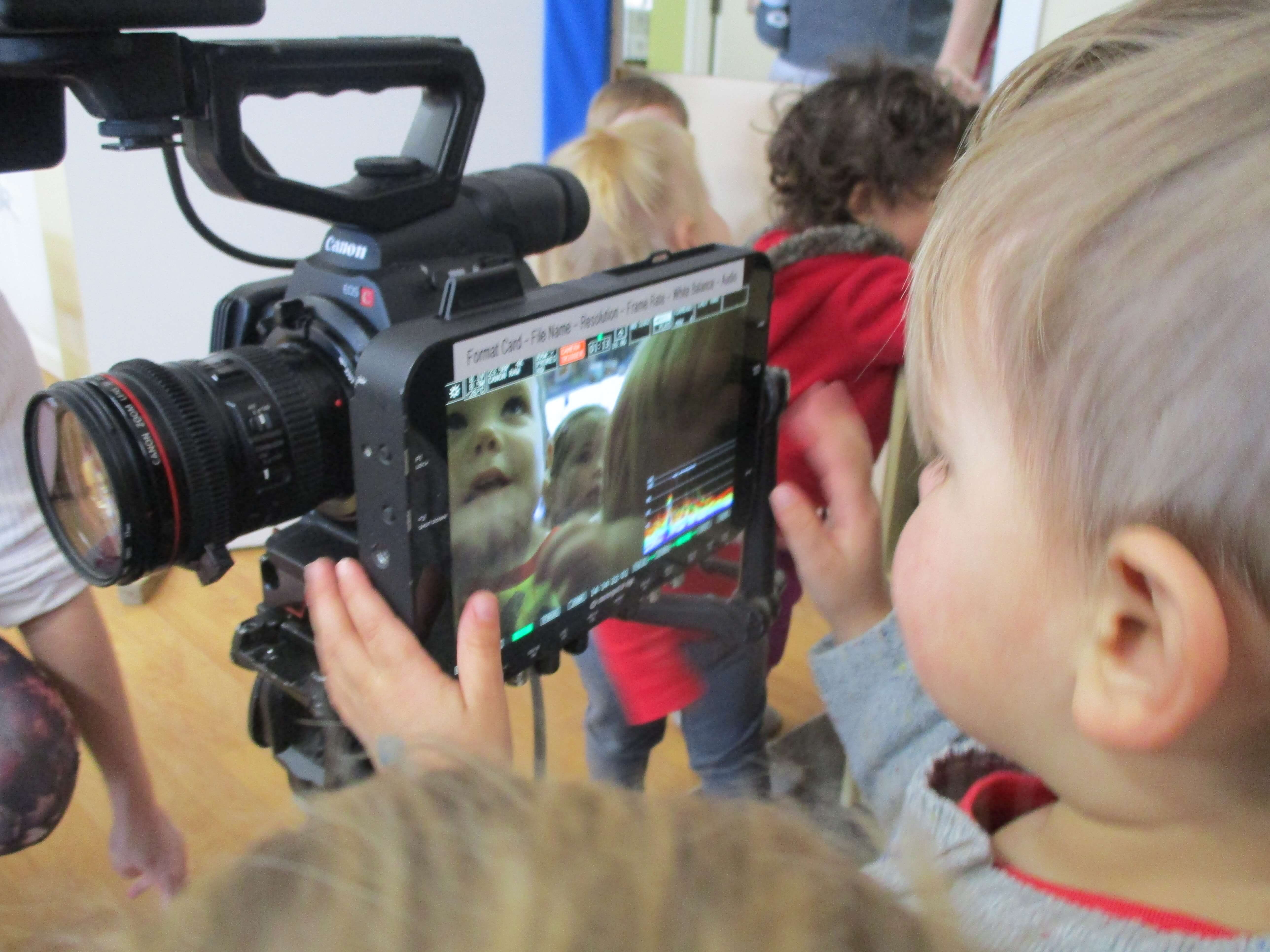 child looking at himself on a video monitor