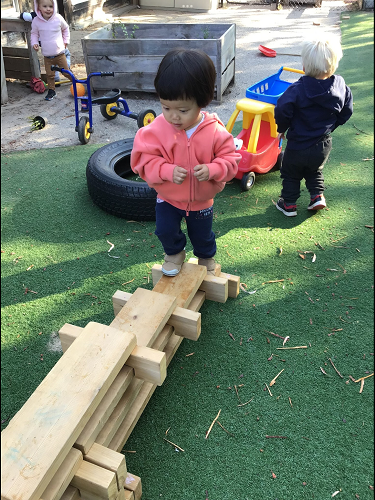 child walking across a beam
