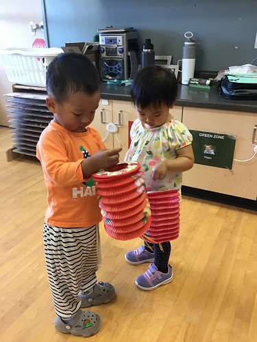 2 children helping hang lanterns