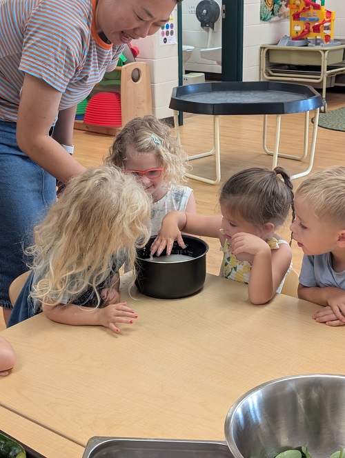 Children soaking rice into a rice cooker
