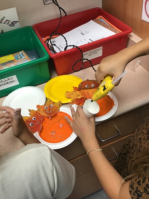 child using a hot glue gun