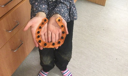 girl proudly showing her horshoe