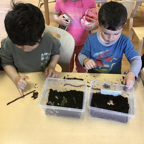 Children exploring the worms on the table. 