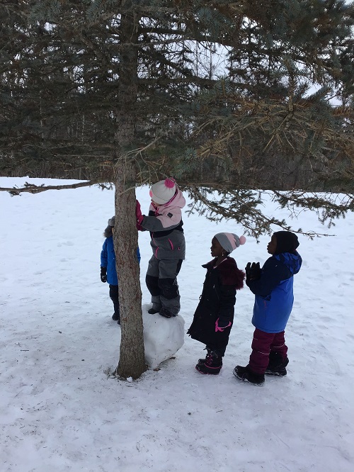Children waiting for their turn to explore climbing on the snowball. 