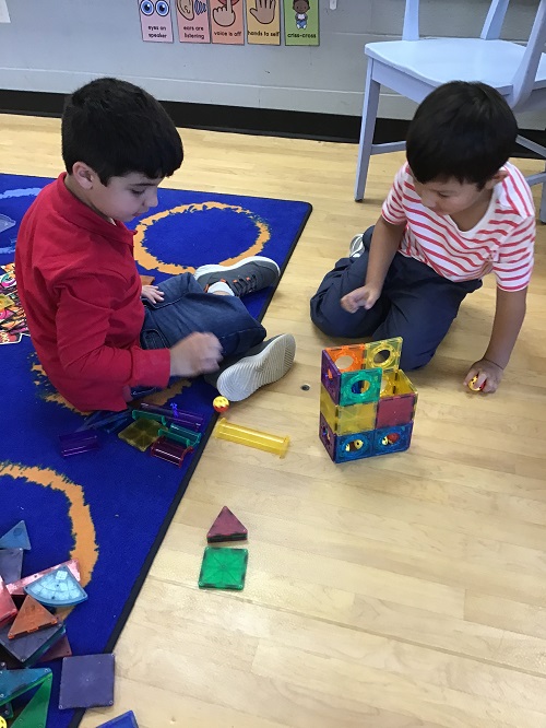 Children building with magnet tiles.
