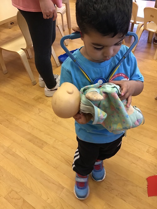 Child checking play baby's heartbeat with a stethoscope. 