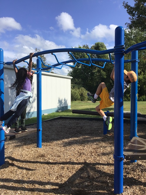 CHildren swinging on monkey bars