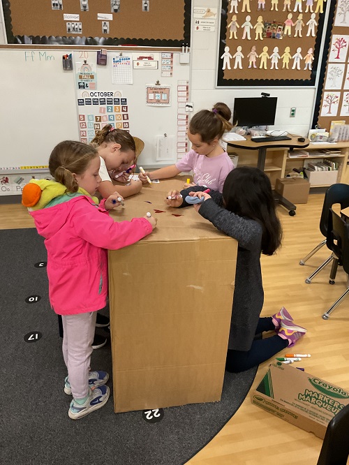 group of children decorating cardboard