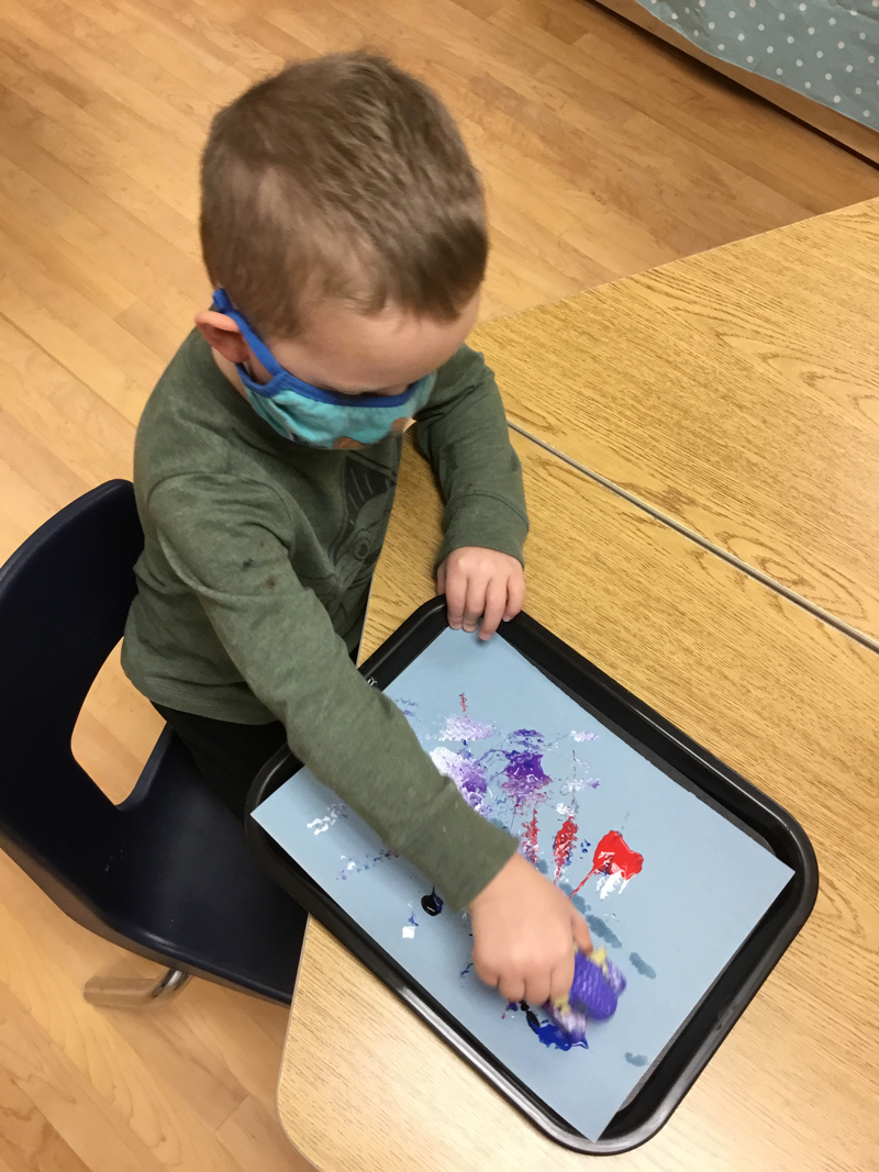 child doing pop art at a table