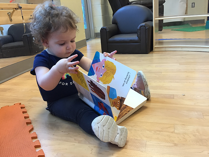 child sitting on the floor reading a book