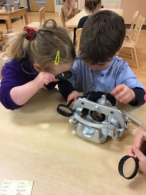 children using magnify glasses to investigate a