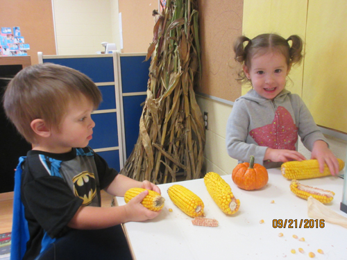 boy and girl holding a corn of cob