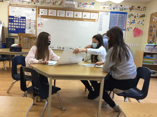 kids sitting at a table making their own board game