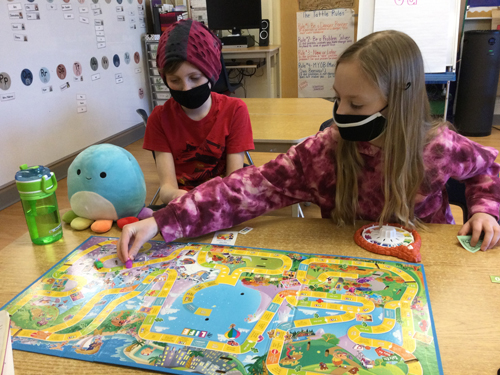 two children playing the board game of life